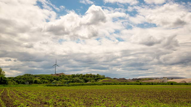 Feld mit Windrad und Allianzarena