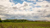 Zeitraffer - Feld mit Windrad und Allianzarena