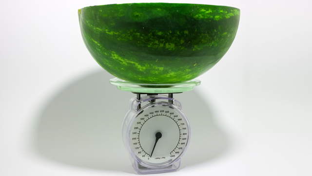 Wassermelone auf Waage Seitenansicht